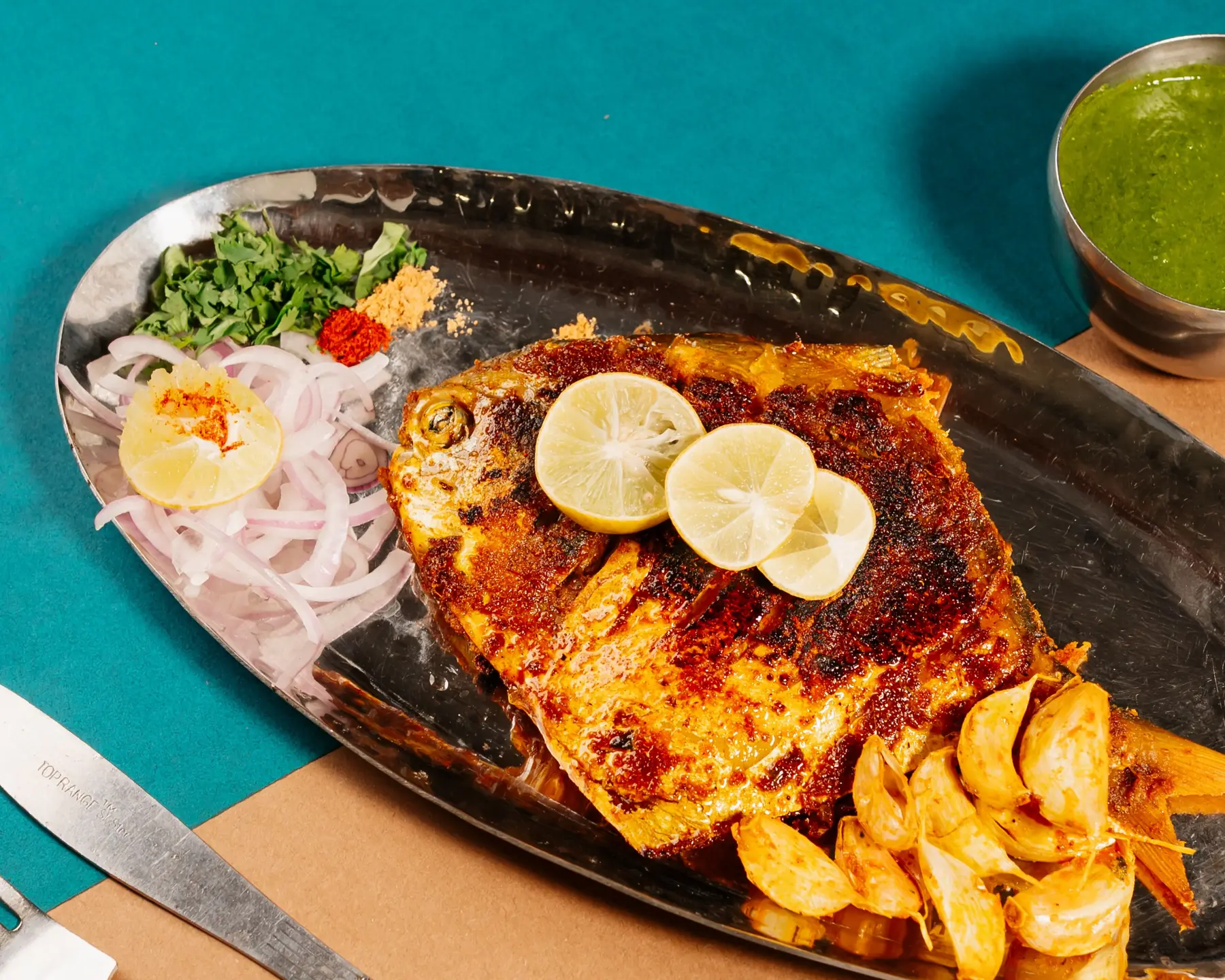 Pomfret tawa fry with lemon, onion and potato wedges
