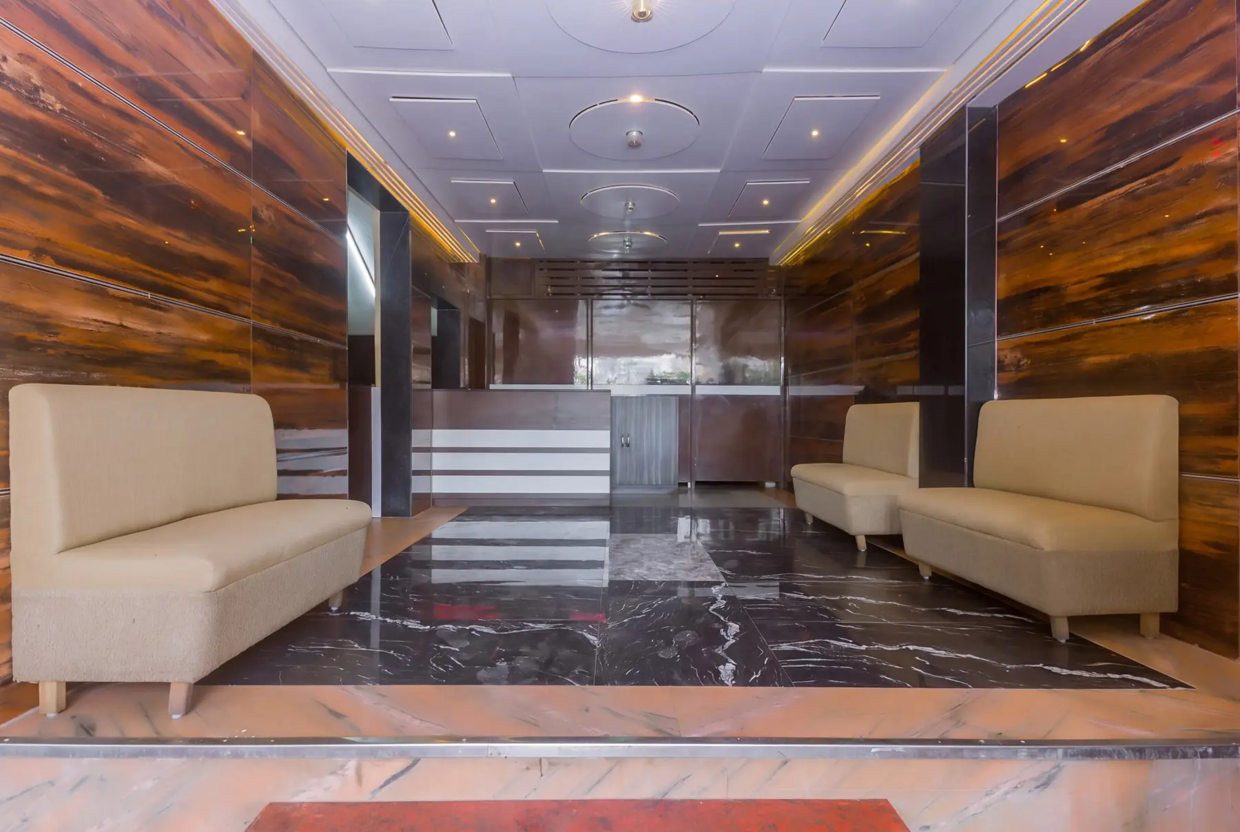 The hotel lobby with cream sofas and wood-panelled walls